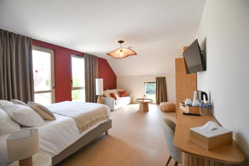 a bedroom with a bed and a desk with a television at Le Clos des Cadoles in Les Riceys