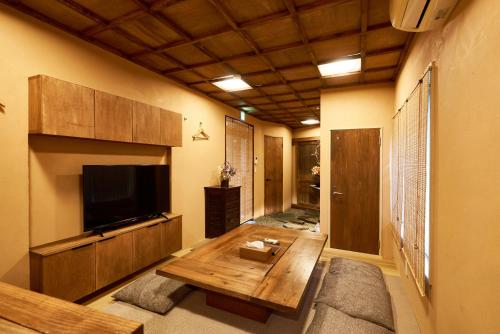 a living room with a tv and a wooden table at 満竹華庵 manchikan in Tokyo