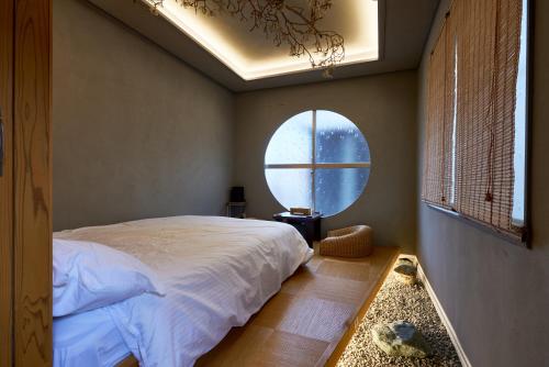 a bedroom with a large bed and a round window at 満竹華庵 manchikan in Tokyo