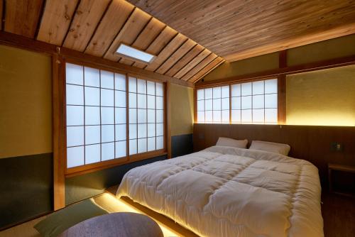 a large bed in a room with two windows at 満竹華庵 manchikan in Tokyo