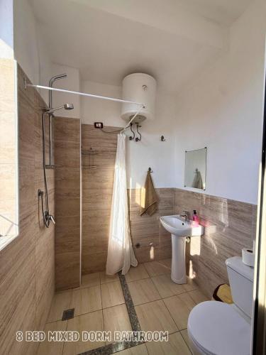 a bathroom with a shower and a toilet and a sink at The Galley Party Hostel in Shkodër