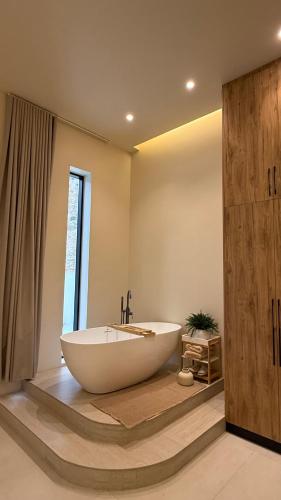 a bathroom with a large tub and a window at Cliff Chalet-Amrat in Al Amarat