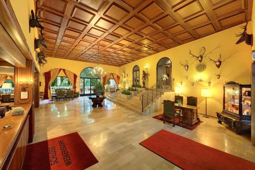 a large living room with a staircase and a lobby at Pytloun Schlosshotel Weikersdorf in Baden
