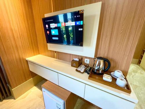 a tv on a wall in a hotel room at Alzetta Hotel by Abiza in Timuran