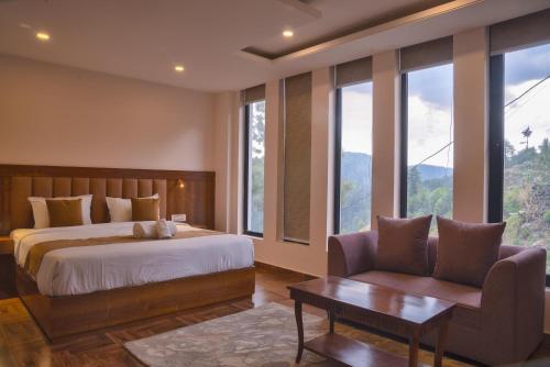 a bedroom with a bed and a chair and windows at Hardys Retreat in Mai Jūbar