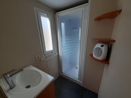 a bathroom with a sink and a shower with a window at Le doux refuge de l'Yères in Touffreville-sur-Eu
