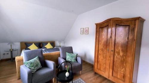 a living room with two chairs and a wooden door at Ferienapartment Weber-Loskill in Mehring