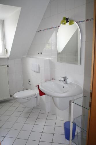 a white bathroom with a sink and a toilet at Ferienapartment Weber-Loskill in Mehring