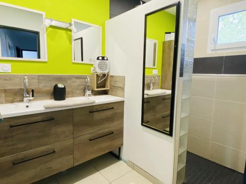 a bathroom with two sinks and a mirror at Les TERRASSES DE LAYOULE in Rodez