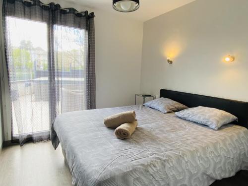 a bedroom with a bed with a stuffed animal on it at Les TERRASSES DE LAYOULE in Rodez