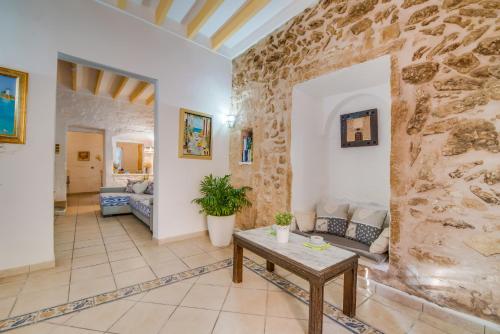a living room with a stone wall and a table at Ideal Property Mallorca - Corro Sant Jaume in Alcudia