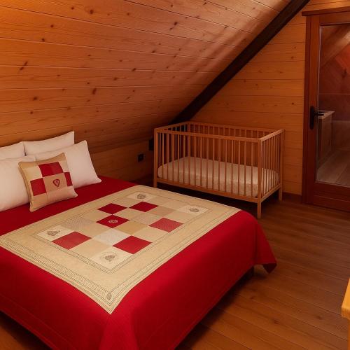 a bedroom with a bed and a crib in a attic at Authentic chalet in Saint-Jean-dʼArves