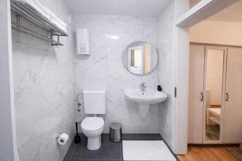 a white bathroom with a toilet and a sink at baadenbergerstay A in Cologne