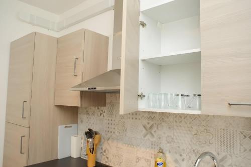 a kitchen with white cabinets and a sink at Grand T2 proche Créteil Soleil et Métro in Créteil