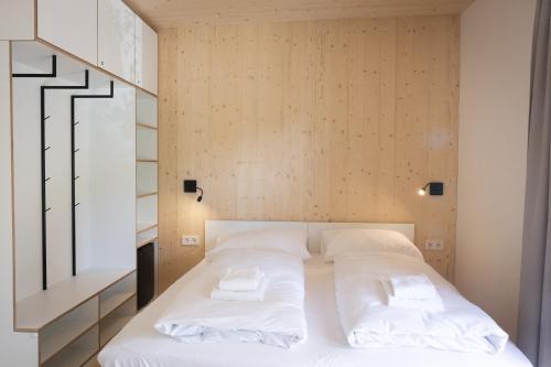 a bedroom with a bed with white pillows at MICAMPA Wien Wienerwald in Vienna