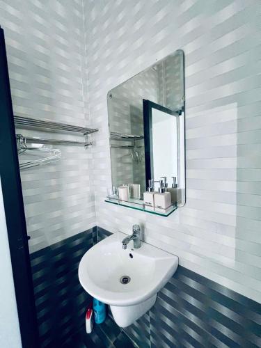 a bathroom with a white sink and a mirror at Tie Homestay in Dong Hoi