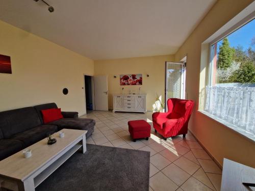 a living room with a couch and red chairs at Ferienhaus Ruth in Walow
