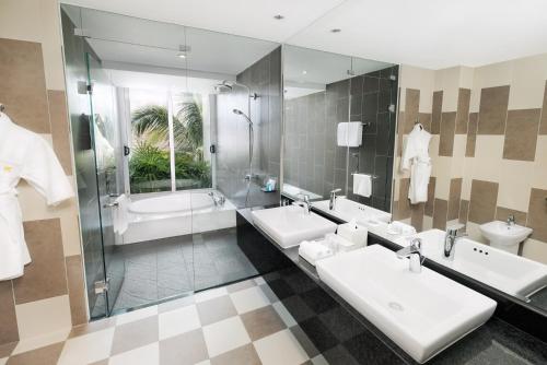 a bathroom with two sinks and a shower at Premier Villa Resort Danang in Danang