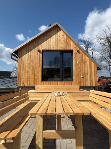 a building with a wooden deck with two benches at Chalupa Lázeňka in Pernink