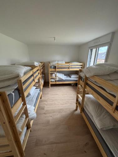 a room with four bunk beds and a window at Maison spacieuse - Perros Guirec in Perros-Guirec