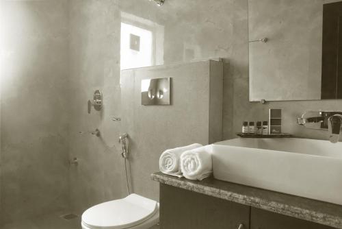a bathroom with a white toilet and a sink at Hardys Retreat in Mai Jūbar