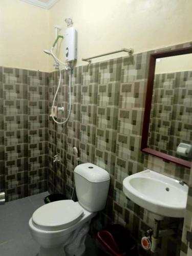 a bathroom with a toilet and a sink at Hidden Valley Guest House in Malapascua Island