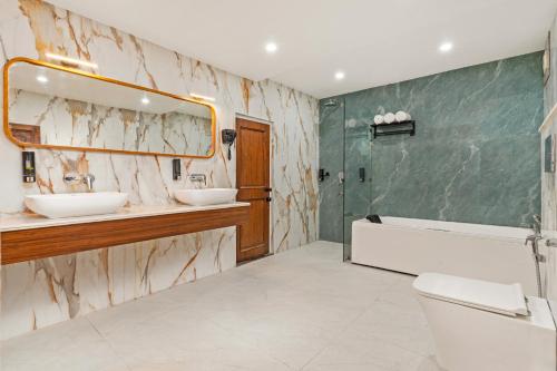 a bathroom with two sinks and a tub and a mirror at Country Inn Rishikesh at Laxman Jhula in Rishīkesh