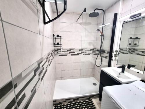 a white bathroom with a shower and a sink at Le TERMINUS in Saint-Cyprien-Plage
