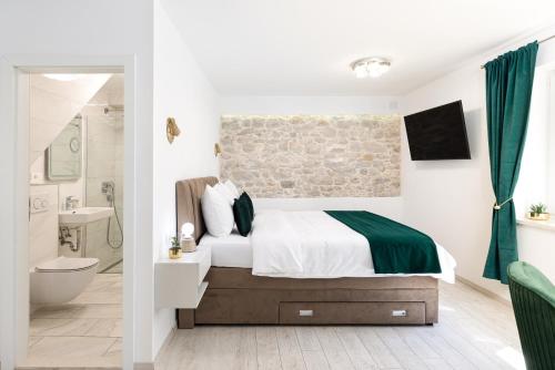 a bedroom with a bed and a bathroom at Lions Heritage Rooms in Split