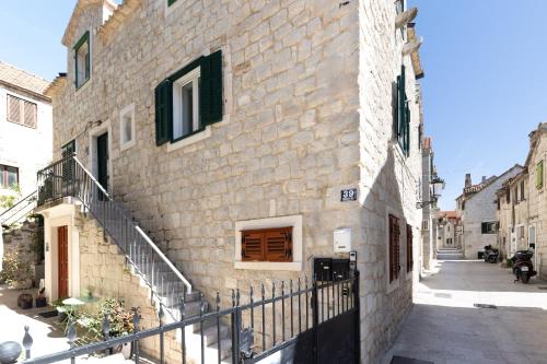 a stone building with a staircase next to a street at Lions Heritage Rooms in Split