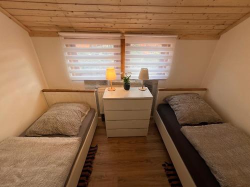 two beds in a small room with two windows at D1 - Klein aber fein in Wernigerode