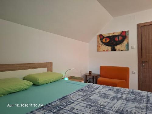 a bedroom with a bed and an orange chair at Garden Vila in Gevgelija