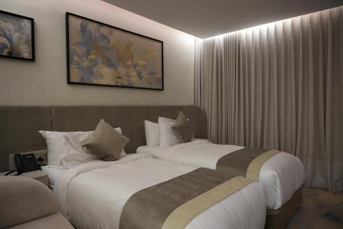 a hotel room with two beds and a couch at Royal Palace Hotel - Al Olaya in Riyadh