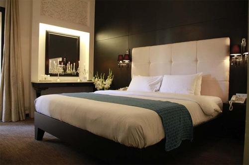 a bedroom with a large bed with a large headboard at Hotel Margala in Islamabad