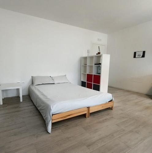 a white bedroom with a bed and a refrigerator at Oltre le mura in Cittadella
