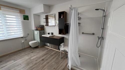 a white bathroom with a sink and a shower at A2 - Viel Platz für alle in Wernigerode