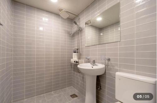 a bathroom with a sink and a toilet and a mirror at Prince Motel in Busan
