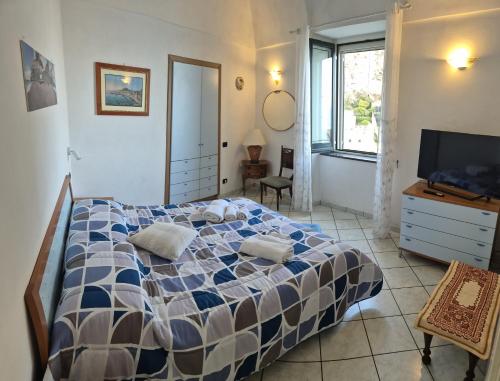 a bedroom with a bed and a dresser and a television at Dany House in Atrani