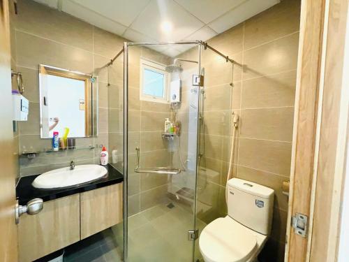 a bathroom with a shower and a toilet and a sink at Saigon Getaway Apartment Thu Duc in Ho Chi Minh City