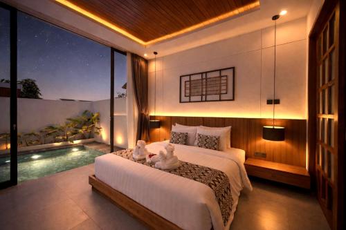 a bedroom with a bed and a swimming pool at Omkara Dharman Ubud Villa By Omkara Experience in Ubud