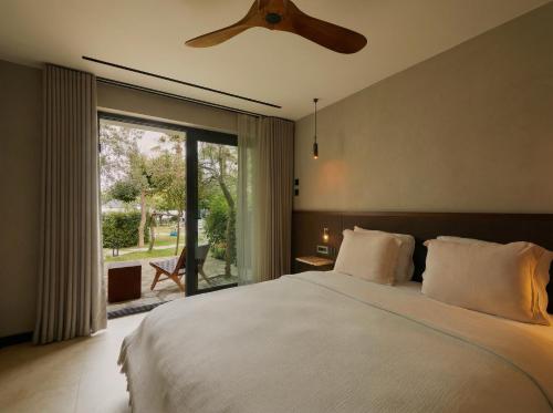 a bedroom with a large bed with a ceiling fan at Selimiye Sardunya Hotel & Restaurant in Marmaris