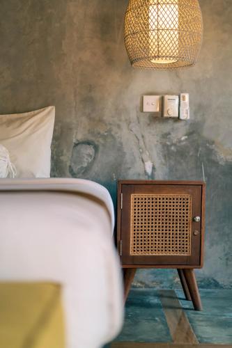 a bedroom with a bed and a nightstand with a lamp at Turtle Villas, Canggu by Manara in Canggu
