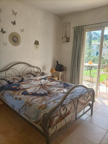a bedroom with a bed with a bedspread with butterflies on it at Les murmures du jardin in Pégomas