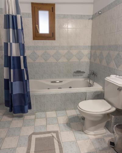 a bathroom with a tub and a toilet and a sink at Studio Merses in Mikrón Khoríon