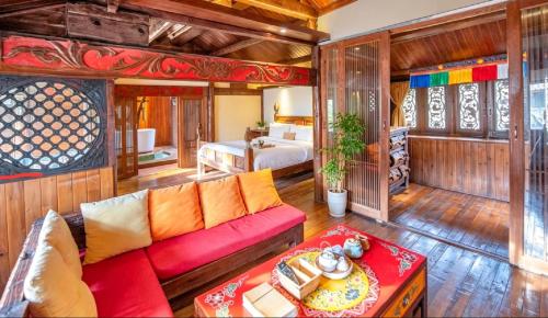 a living room with a red couch and a bedroom at 丽江无尔雪山下泳池花园民宿 in Lijiang