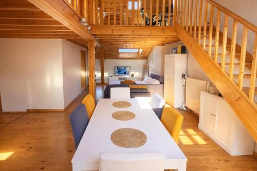 a dining room with a white table and chairs at Loft Chaleureux - Le Chalet Montois in Mons