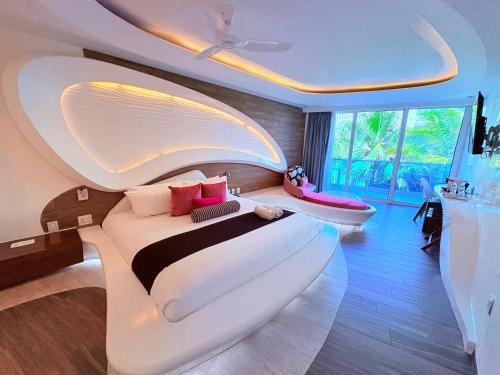 a bedroom with a large white bed and a tub at Condohotel The Carmen Deluxe Oceanview King Suite in Playa del Carmen