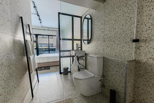 a bathroom with a toilet and a mirror at inn here in Johannesburg
