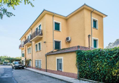 a yellow building with a car parked in front of it at Hostal La Pastora in Candeleda