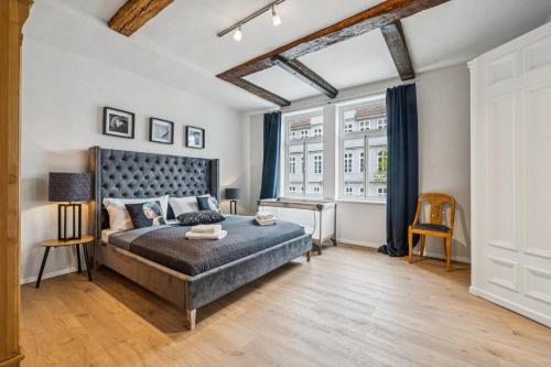 a bedroom with a bed and a desk and windows at MEL&BENS Altstadt Suites mit Parkoption in Celle